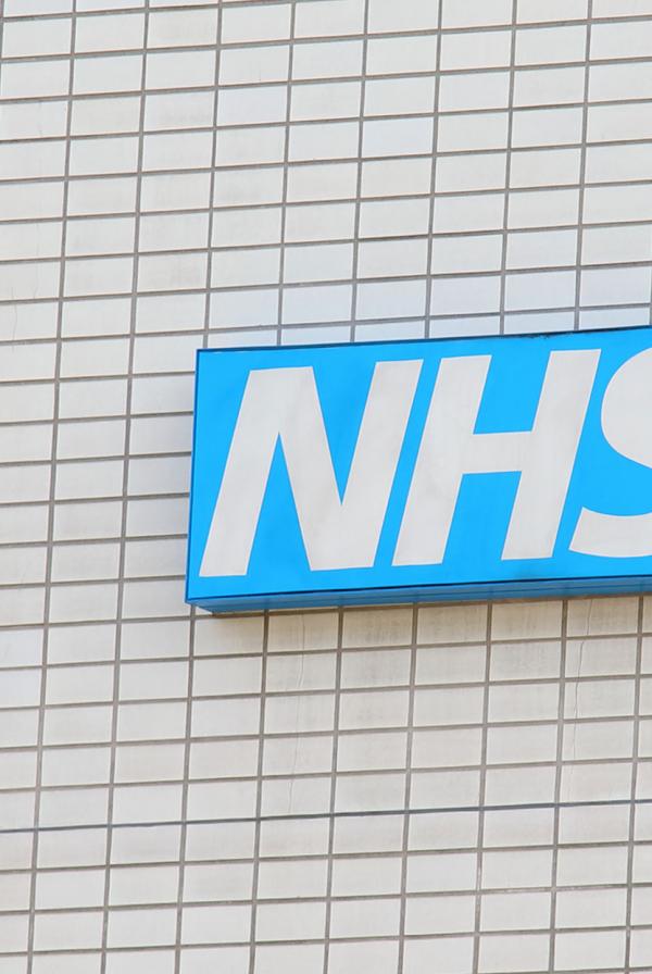 An NHS sign on the side of a building.